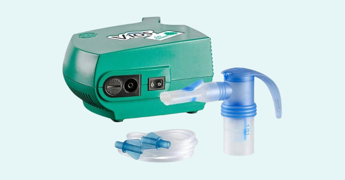 Vios nebulizer compressor unit with attached nebulizer cup and mouthpiece, plus separate connecting tubing shown below.