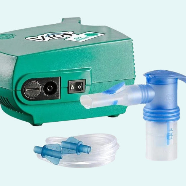 Vios nebulizer compressor unit with attached nebulizer cup and mouthpiece, plus separate connecting tubing shown below.