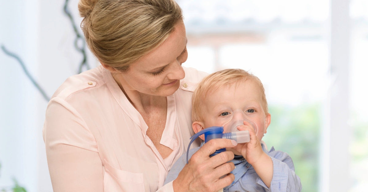 Mom using a handheld nebulizer to help with RSV