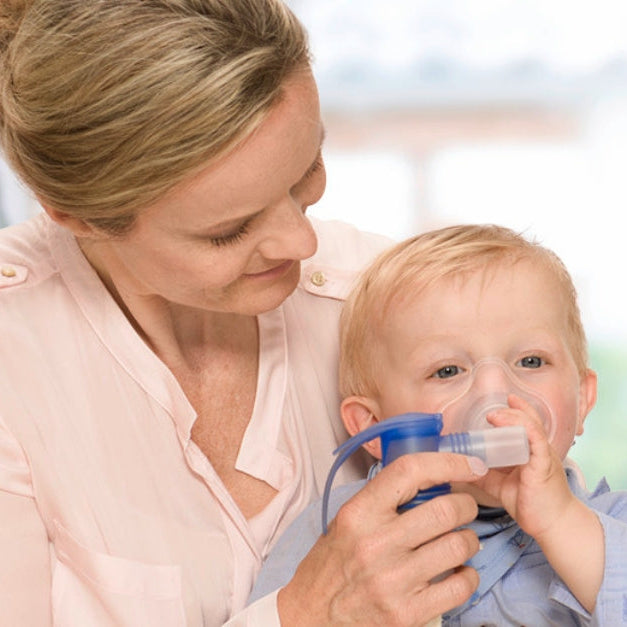 Mom using a handheld nebulizer to help with RSV