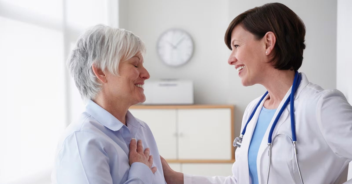 Patient and doctor smiling at each other in a medical office.
