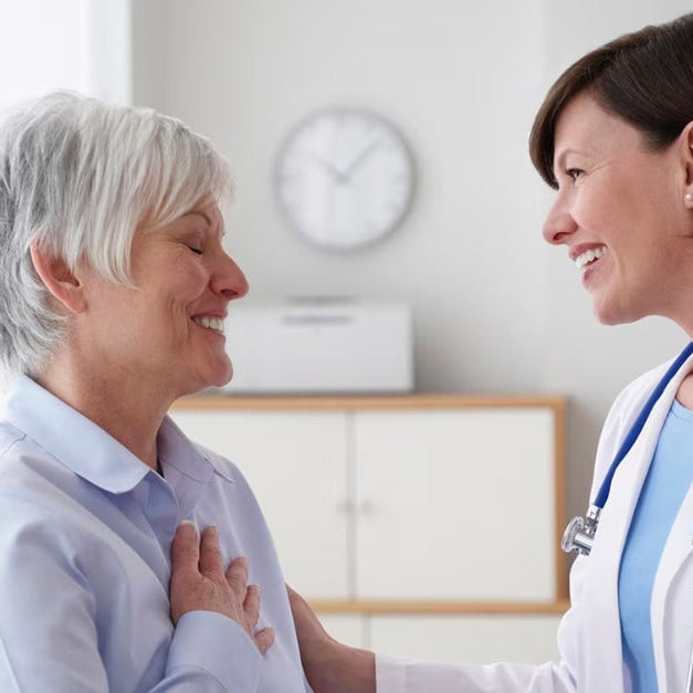 Patient and doctor smiling at each other in a medical office.